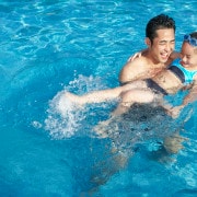 Father and daughter swimming at the pool