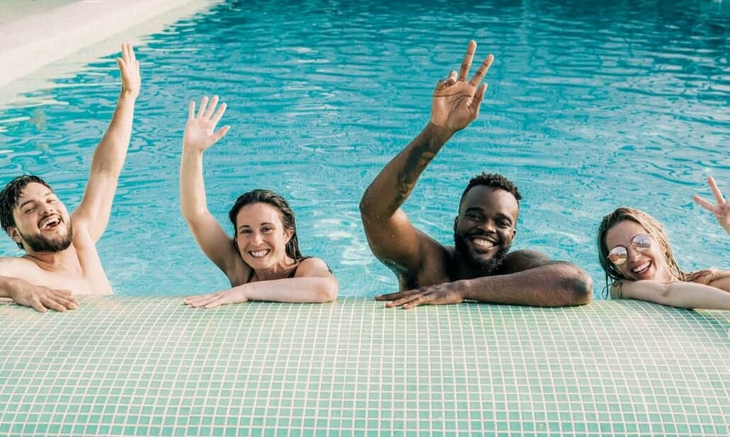 people having fun inside swimming pool party indoors during summer vacations